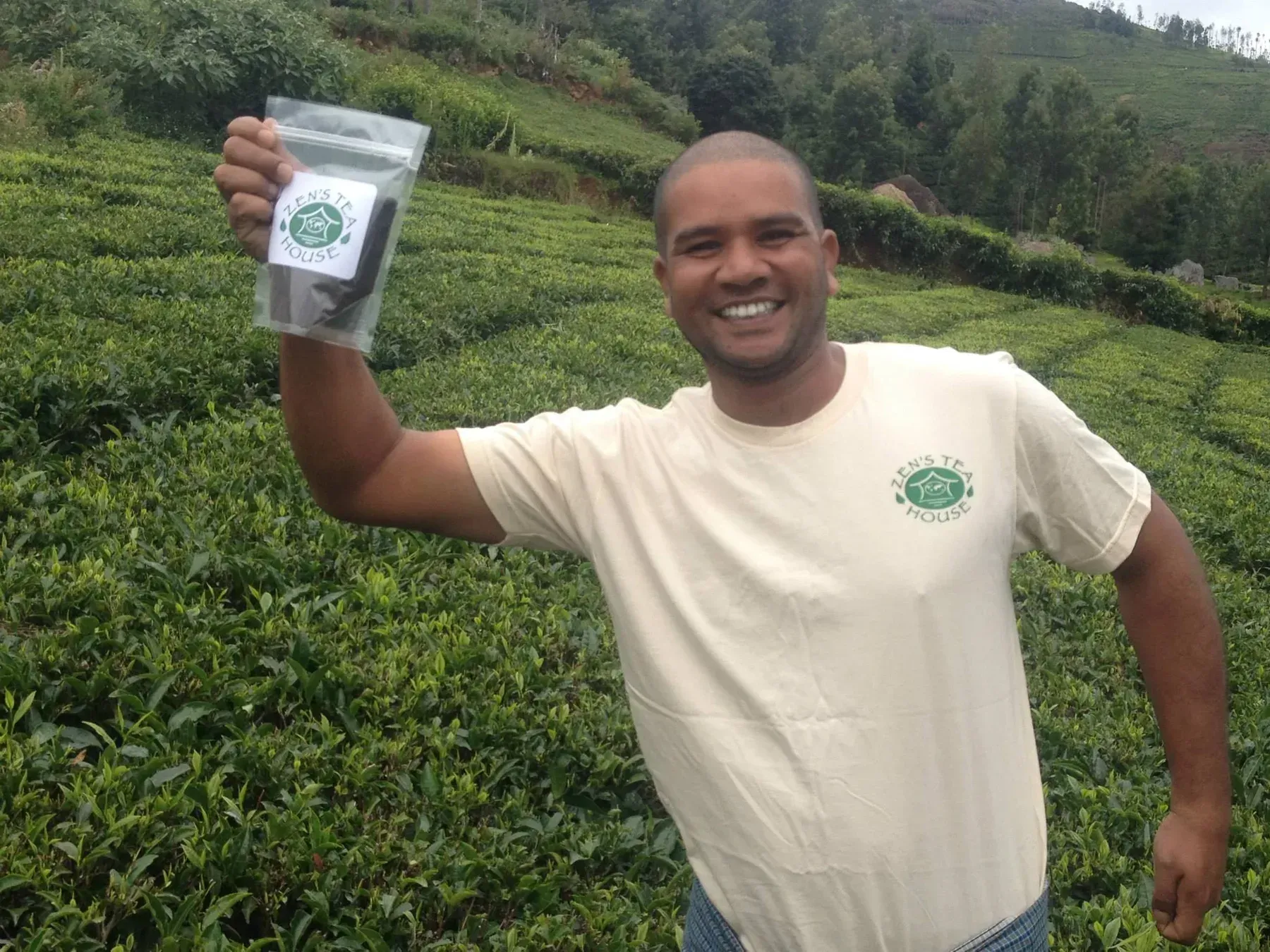 Fernando holding up a bag of Zen’s tea in a tea garden